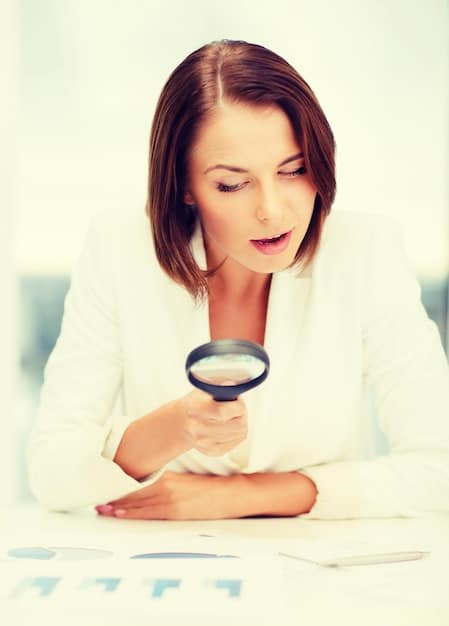 A close-up shot of a businesswoman reviewing financial documents, with a magnifying glass highlighting key numbers and charts. The image conveys the importance of understanding financial details when applying for government funding programs.
