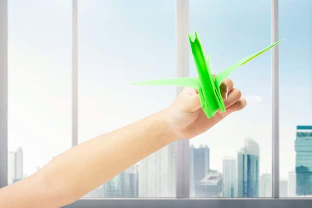 A close-up shot of a hand pointing at a graph showing increasing investment in renewable energy, with labels highlighting key tax credit percentages and dates. The background is a blurred image of wind turbines.