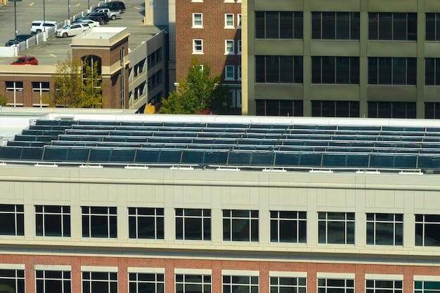 Solar panel installation on a large commercial building in an urban area. The focus is on the roof of the building, covered extensively with solar panels. The backdrop includes other buildings, a clear sky, and elements of a bustling city, indicating investment in renewable energy in urban infrastructure.