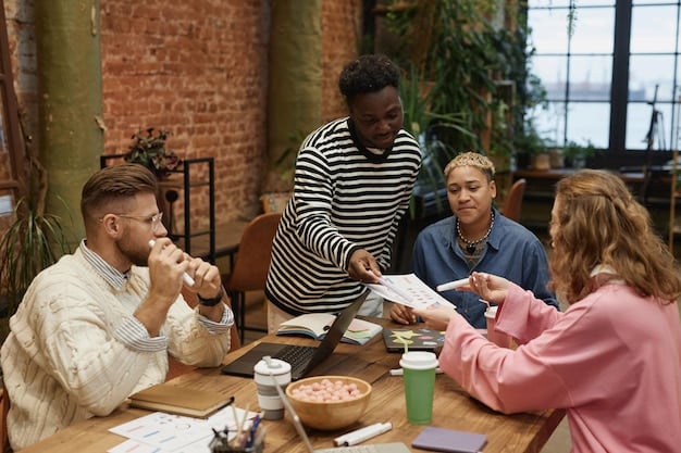 A diverse group of people sitting around a table, engaged in a training session. The focus is on a presenter pointing to a slide that reads 