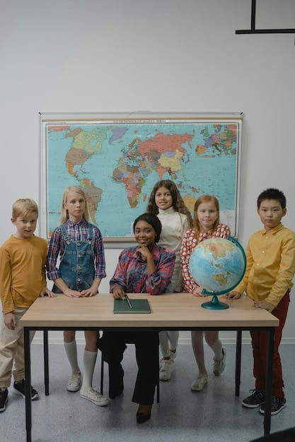 A group of children in a classroom in a developing country, with a sign indicating the project is supported by US foreign aid, focusing on education.