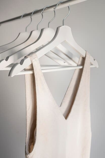 A minimalist and neatly organized capsule wardrobe displayed on a clothing rack, featuring versatile, neutral-colored garments, emphasizing simplicity and functionality.