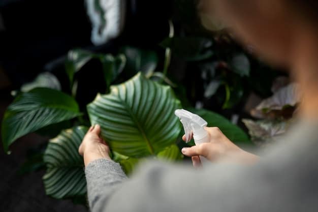 Close-up of a gardener's hand gently removing a pest from a plant leaf, illustrating hands-on, natural pest control in a home garden.
