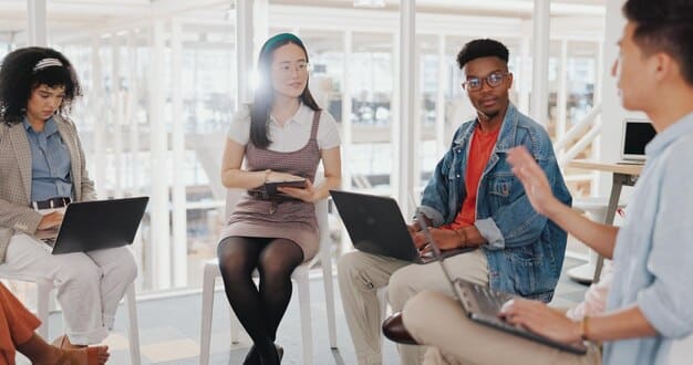 A diverse group of young professionals in a collaborative workspace, engaged in a brainstorming session with a whiteboard covered in flowcharts and diagrams, indicative of future-focused problem-solving in a STEM-driven economy.