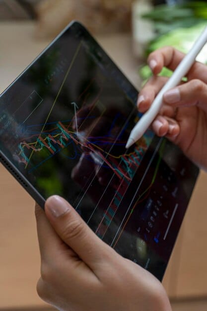 A detailed close-up of a hand drawing a financial graph on a tablet, with various financial charts and stock market tickers in the background, symbolizing financial analysis and strategic planning.