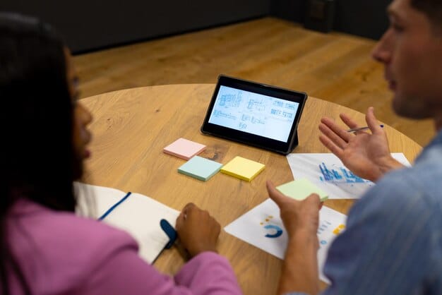 A designer conducting a user research session, observing a participant interacting with a complex digital prototype on a tablet, with sticky notes and affinity mapping visible in the background.