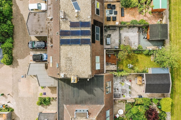An aerial view of a vibrant residential neighborhood with numerous homes featuring solar panels on their roofs, showcasing a successful community adoption of solar energy.