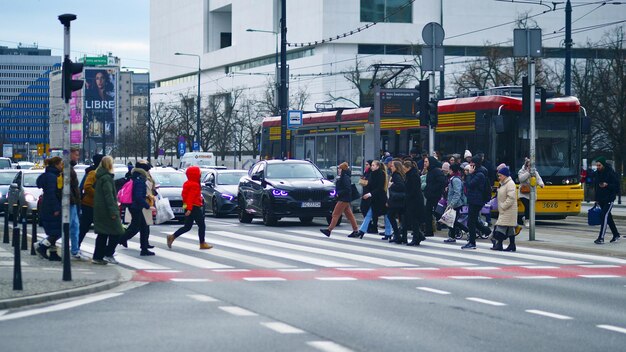 A busy city intersection with pedestrians crossing the street, a bus pulling up to a stop, and cyclists in a dedicated bike lane. The scene is vibrant, showcasing various modes of sustainable transportation coexisting. Relates to What are the Latest Government Initiatives Supporting Sustainable Transportation in US Cities in 2025?, highlighting the importance of integrating different modes of transportation.