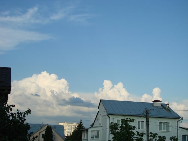 Solar panels on a suburban rooftop, with a clear blue sky, symbolizing renewable energy adoption and potential household savings.
