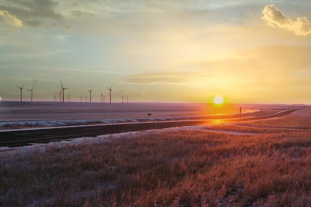 A modern wind farm at sunset, placed next to a field with solar panels. The sky is warm and the image conveys a sense of technological advancement and hope for clean energy. The caption mentions the growing investment in renewable energy sources driven by updated US energy policies. It should illustrate how updated US energy policy impacts the development of renewable energy.