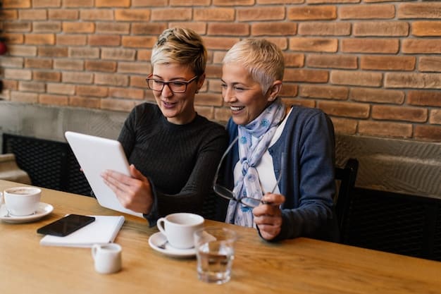 Two professionals, one senior and one junior, engaged in a focused conversation over coffee, signifying a mentorship relationship and knowledge transfer.