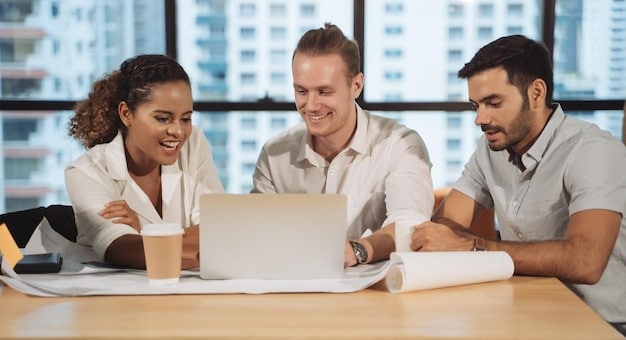 A diverse group of young professionals sitting around a conference table engaged in a financial planning discussion, looking at a laptop and documents.